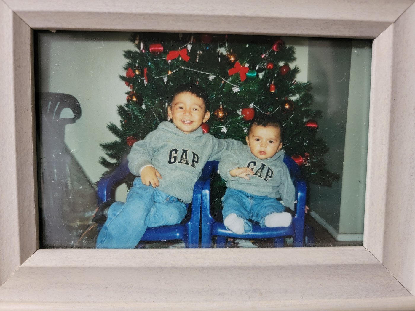 A framed childhood photo of two children at Christmas