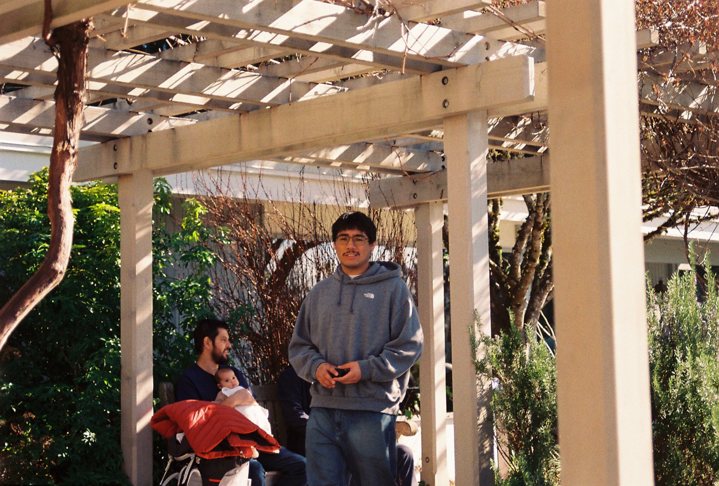 Family members gathering beneath an outdoor pergola