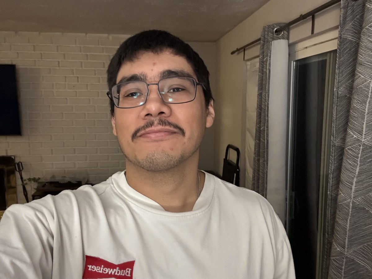 A more recent portrait of Erick with shorter hair and glasses