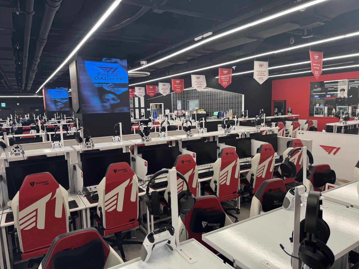 Rows of gaming computers and red-and-white chairs in a Korean gaming venue