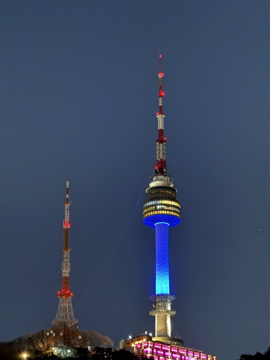 An illuminated observation tower against the evening sky