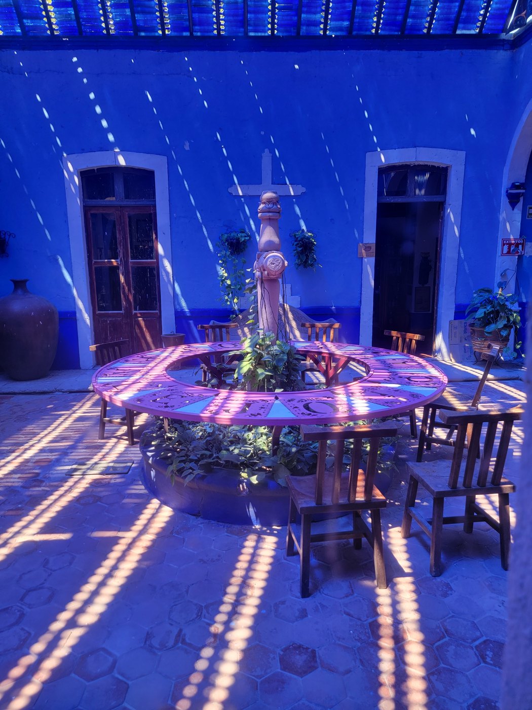 A blue courtyard with a table and hanging decorations