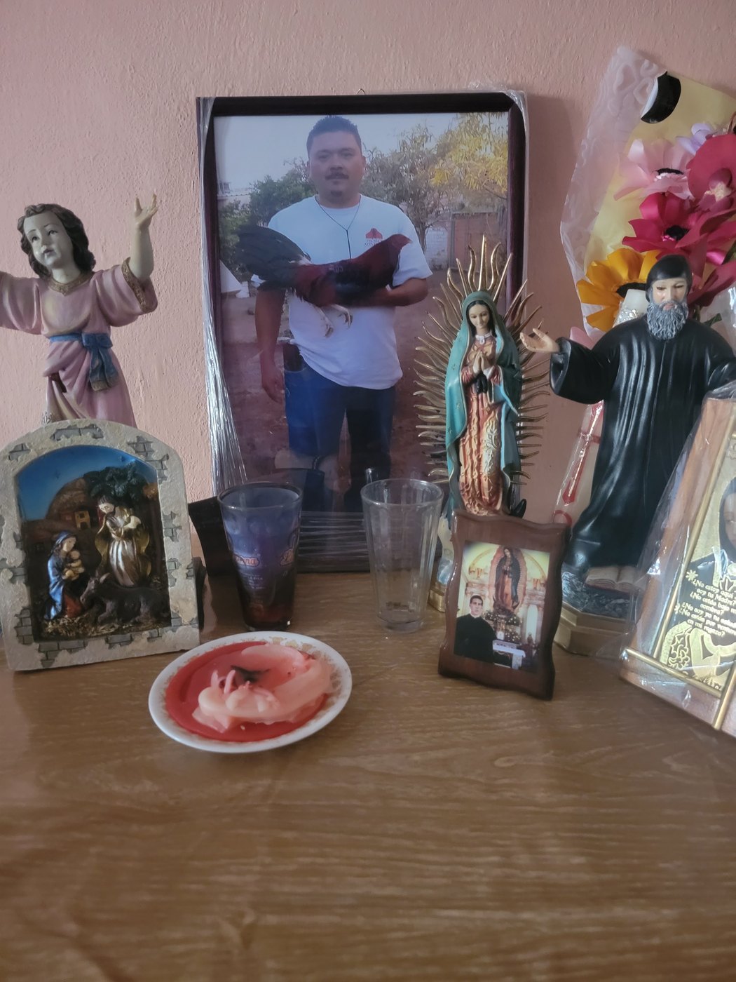 A home memorial with a framed portrait, flowers, and keepsakes