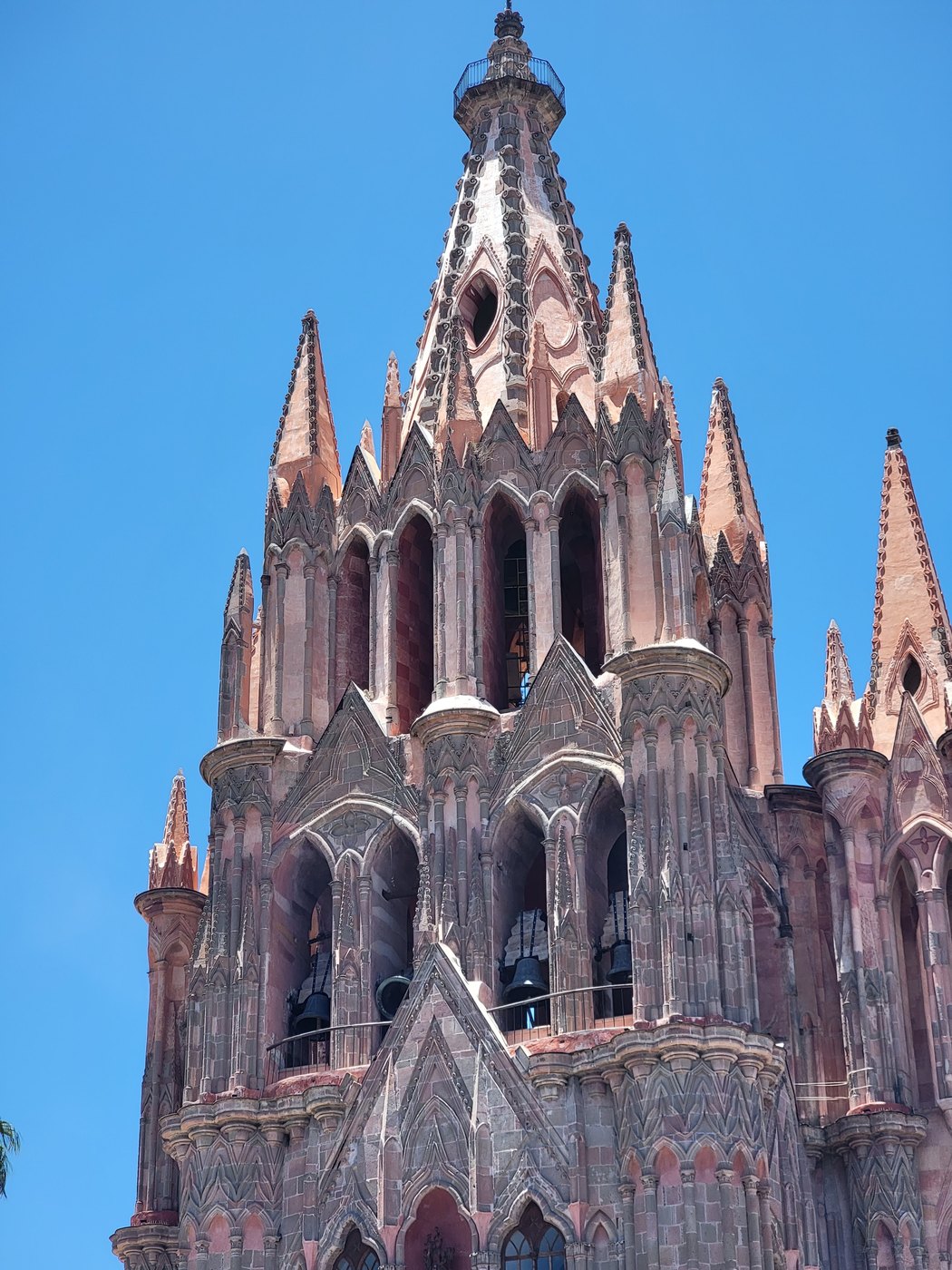 A Gothic church tower against a clear blue sky