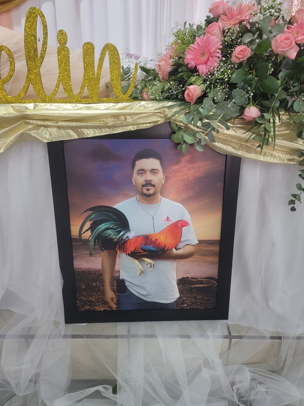 A framed portrait surrounded by pink flowers