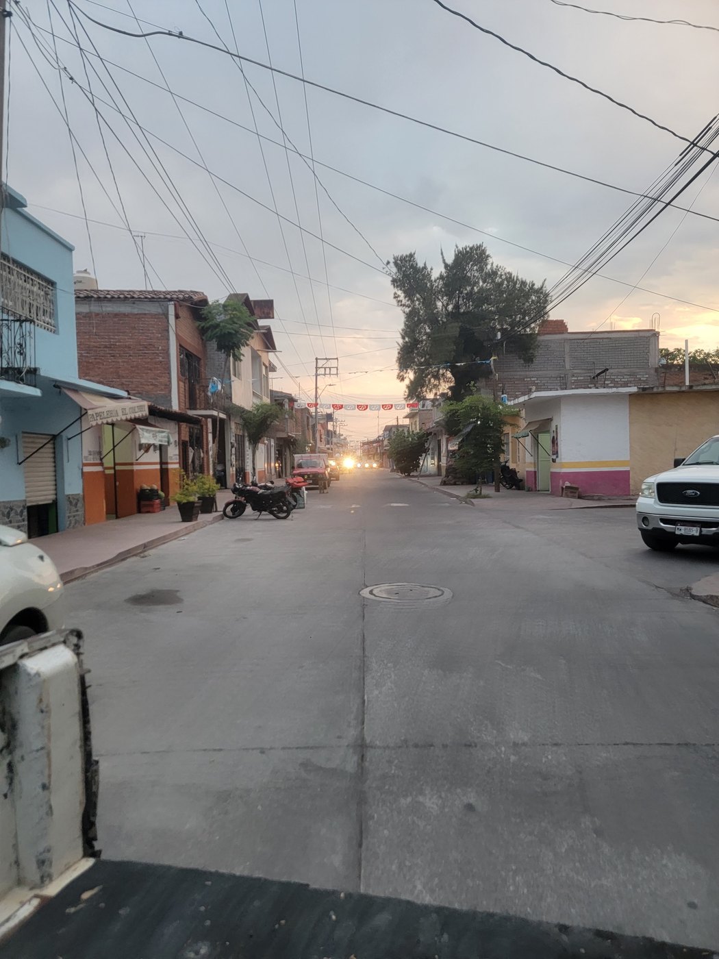 A neighborhood street in Mexico beneath an evening sky