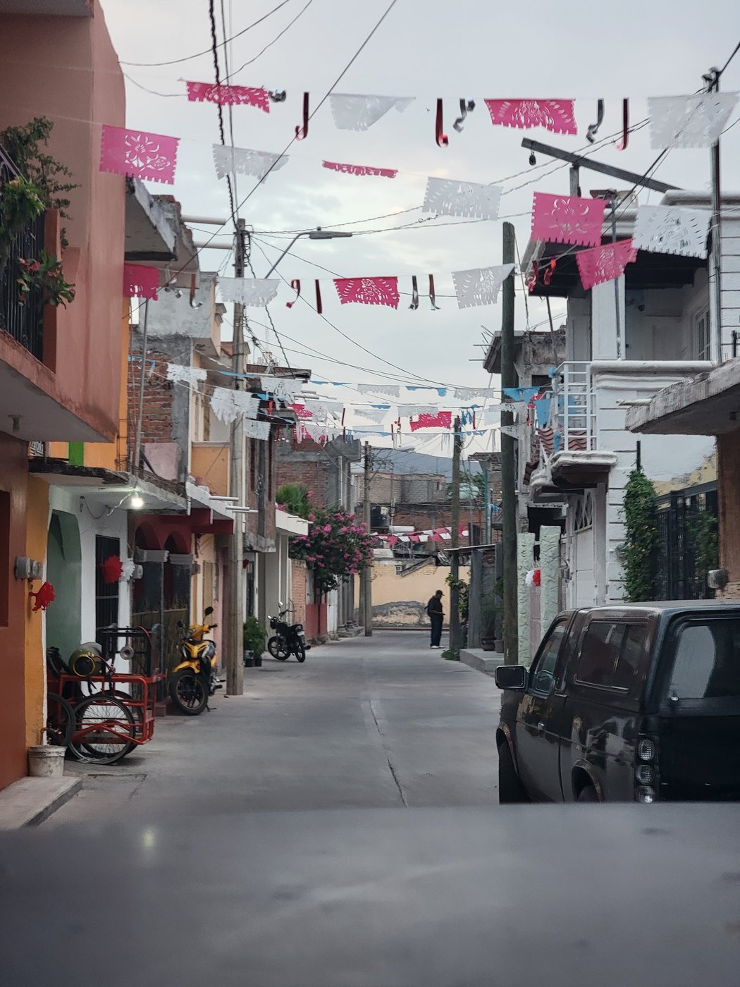 A neighborhood street decorated with colorful papel picado