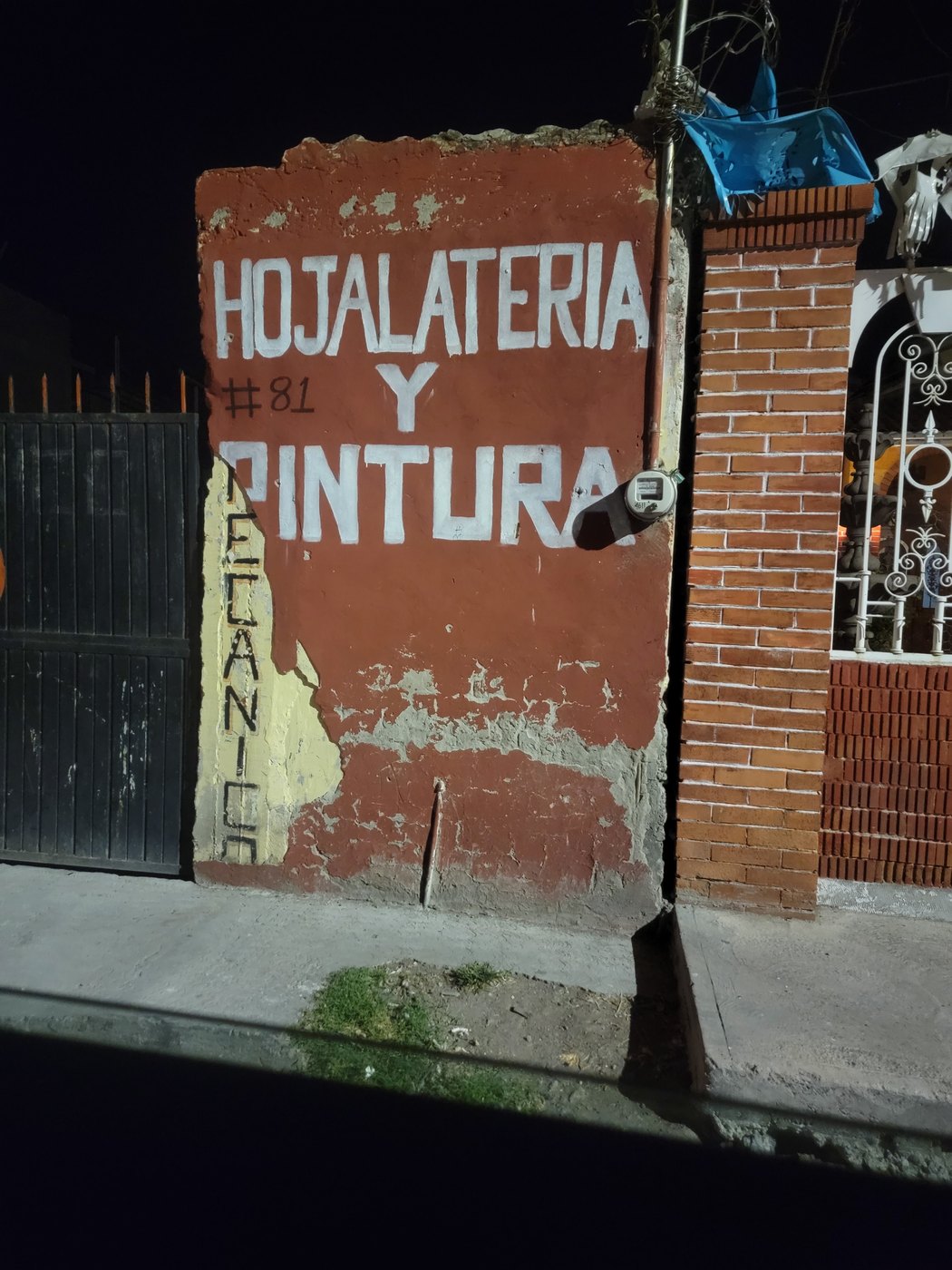 A painted hotel and restaurant sign on a brick wall at night