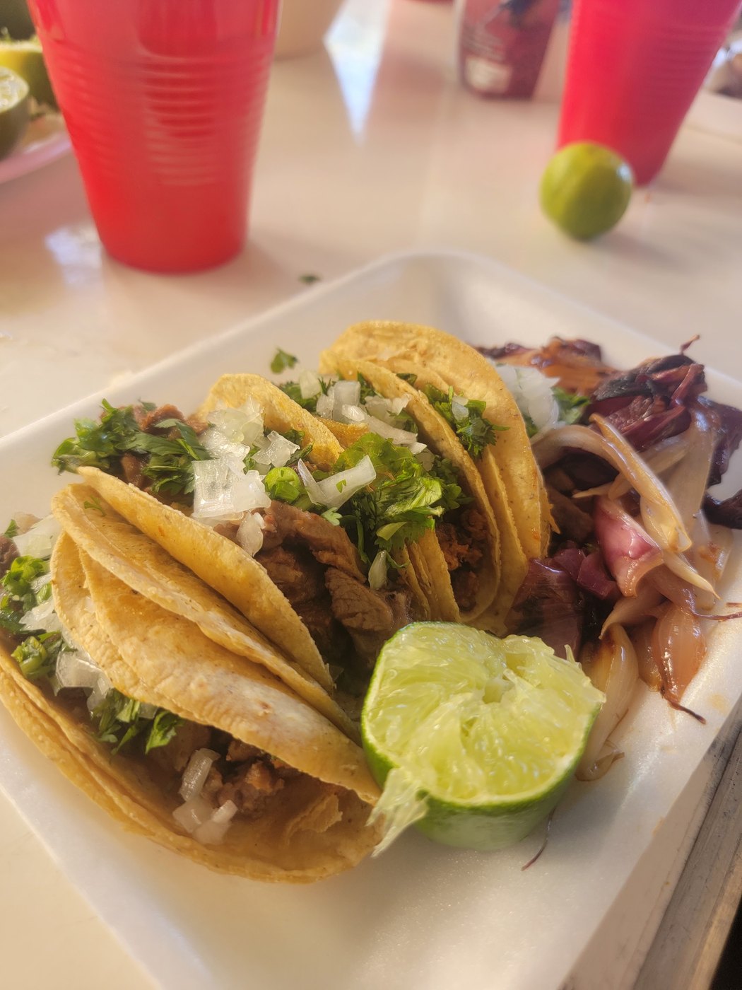 A plate of tacos served with lime and red onion