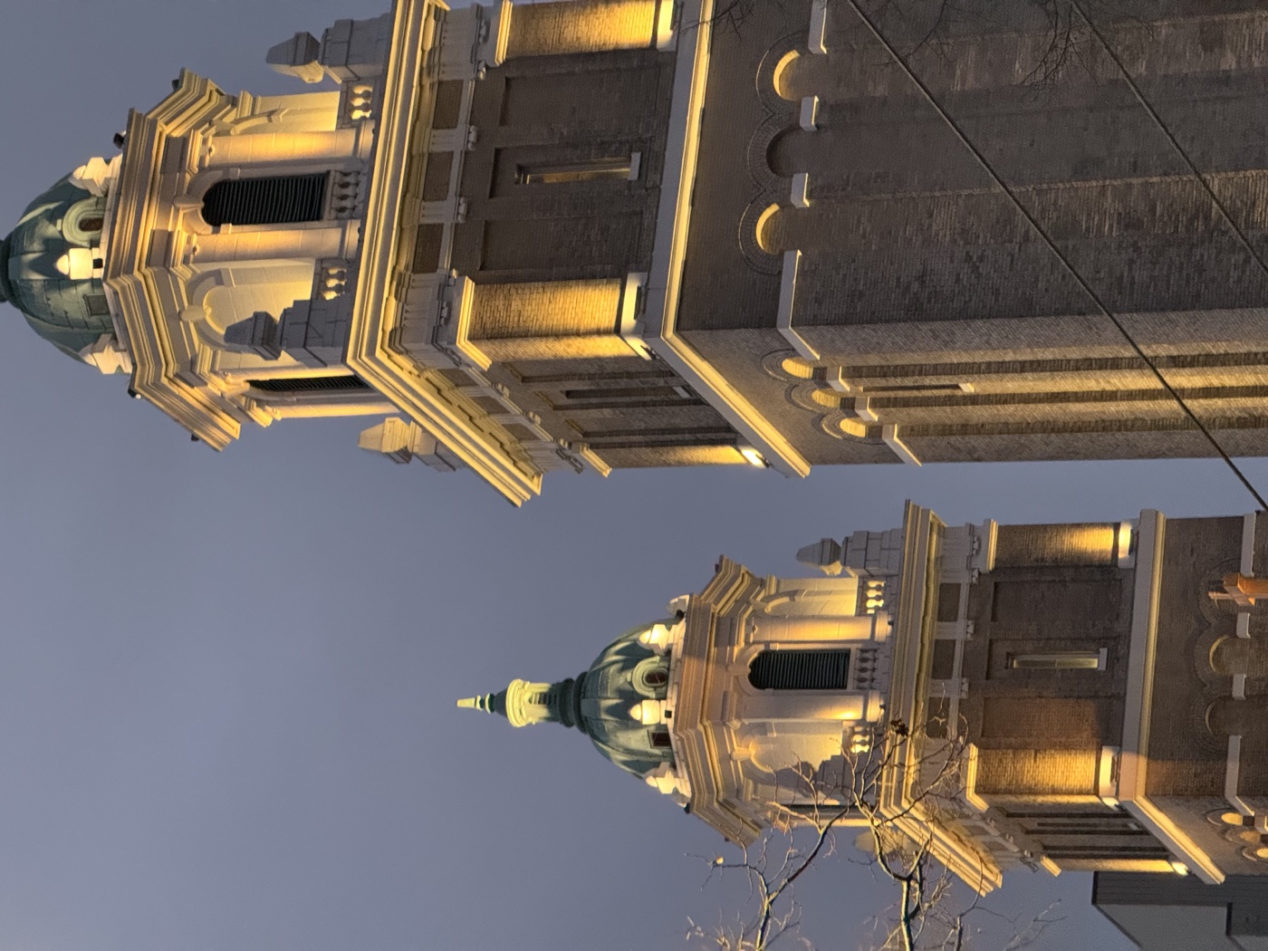 Two illuminated church towers against the evening sky