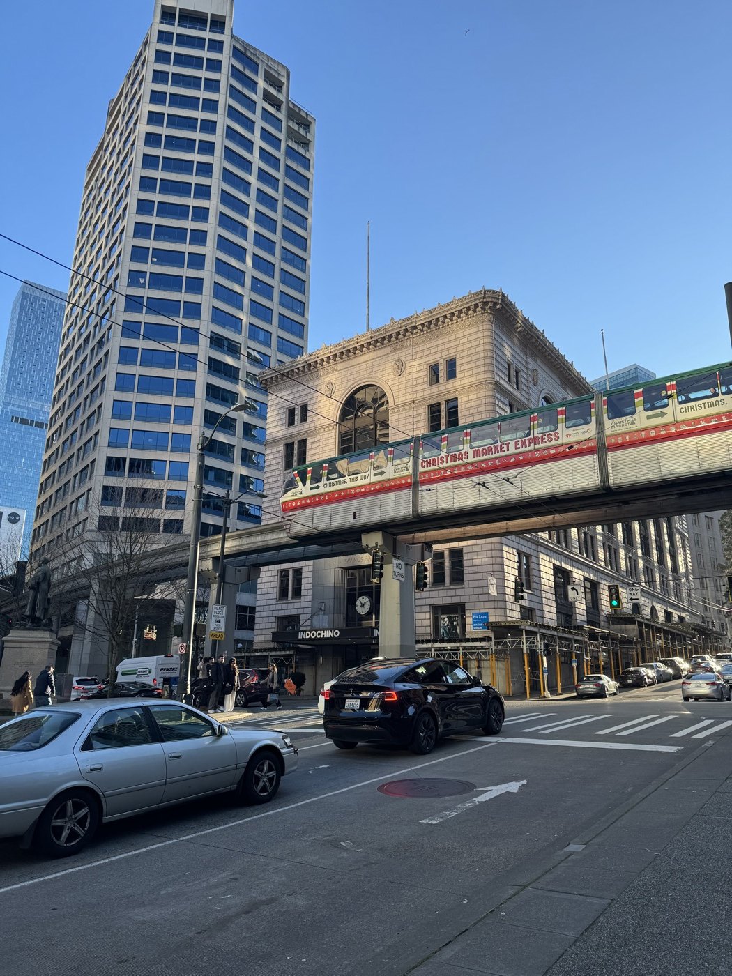 A monorail crossing above a downtown Seattle street