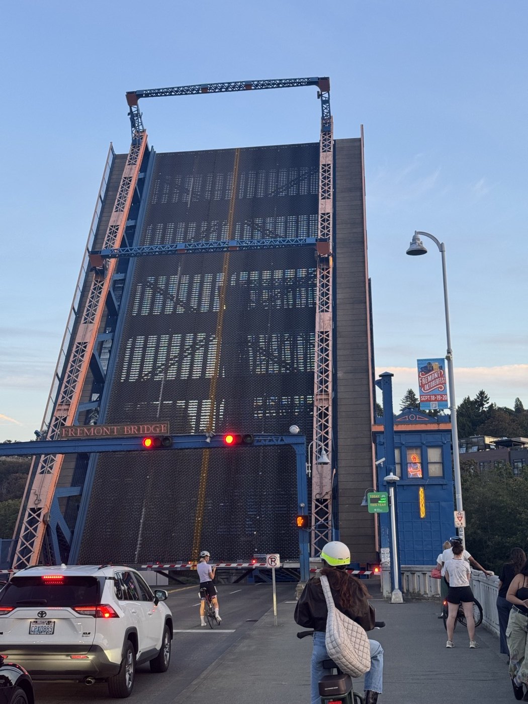 A raised drawbridge with cyclists and pedestrians waiting to cross