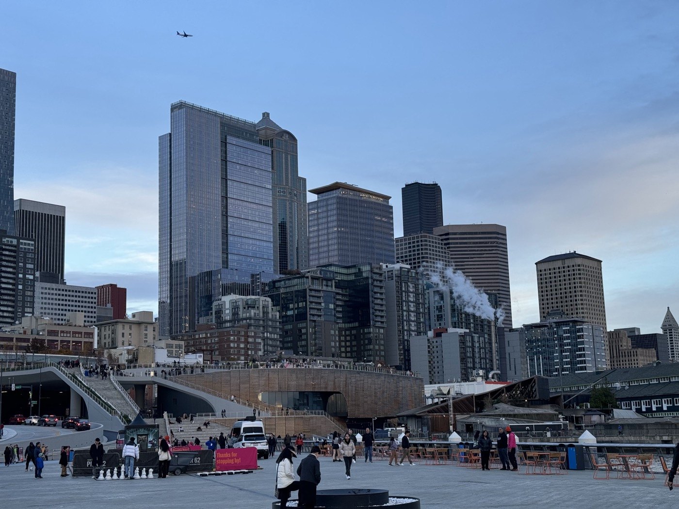 Seattle waterfront with people walking beneath the downtown skyline