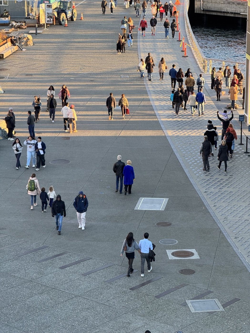 People walking along the Seattle waterfront promenade